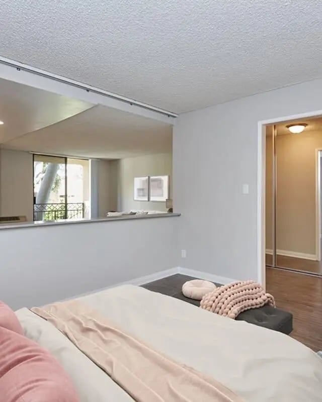 Bed with pink pillows and blanket living room at Ariel Court in Los Angeles Student Accommodation