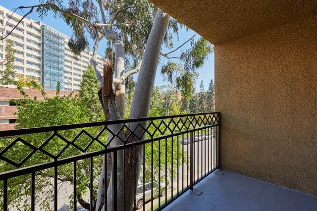 Balcony with ornate railing overlooking trees and buildings Balcony at Ariel Court in Los Angeles Student Accommodation