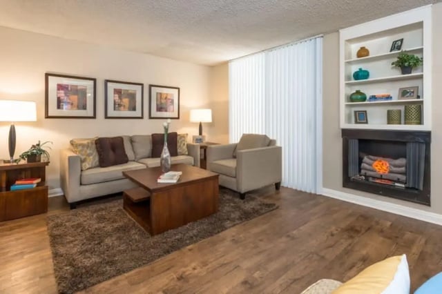 Sofa armchair coffee table bookshelves fireplace living room at Ariel Court in Los Angeles Student Accommodation