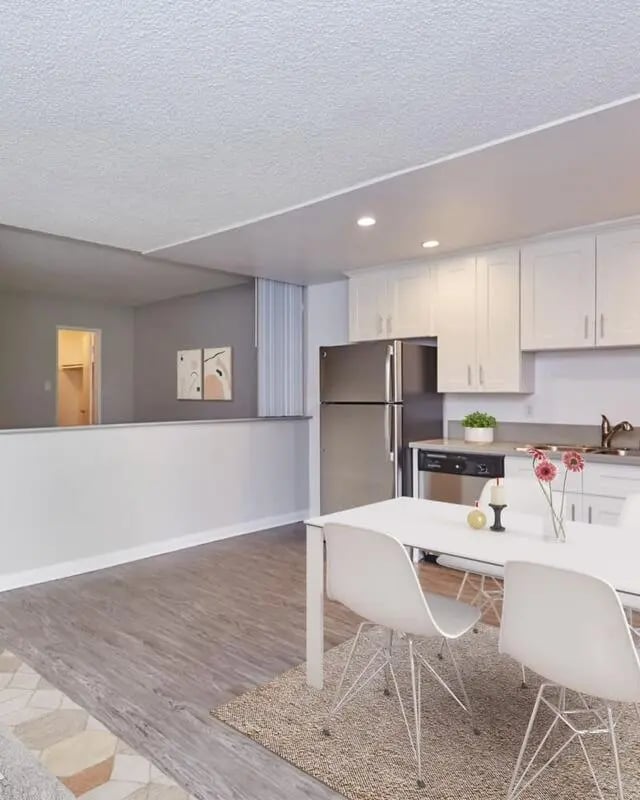 Dining table with chairs stainless steel fridge kitchen area at Ariel Court in Los Angeles Student Accommodation