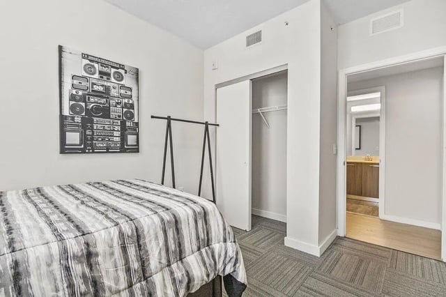 Bed artwork closet and bathroom view bedroom at 4th Street Commons Apartments in Miami Student Accommodation