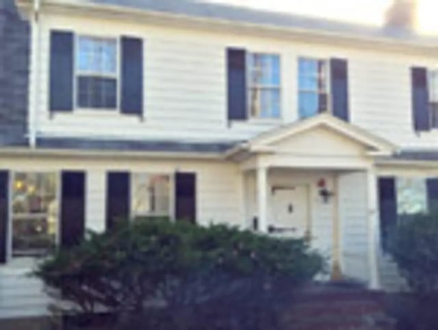 White house with black shutters and bushes exterior at Ashley Management Corporation in Ithaca Student Accommodation