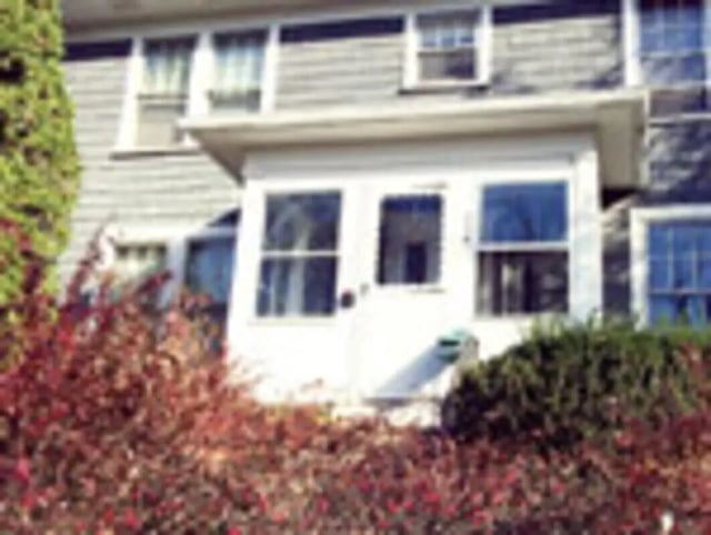 White porch with windows and red bushes exterior at Ashley Management Corporation in Ithaca Student Accommodation