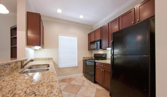Granite counters stainless sink black appliances kitchen at Ashton Lane Luxury Apartments in Gainesville Student Accommodation