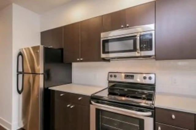Stainless steel appliances dark cabinets white countertop kitchen at Cooper Village in Camden Student Accommodation