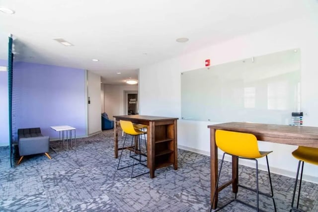 Tall tables yellow chairs whiteboard study lounge at The Flats At Carrs Hill in Athens Student Accommodation