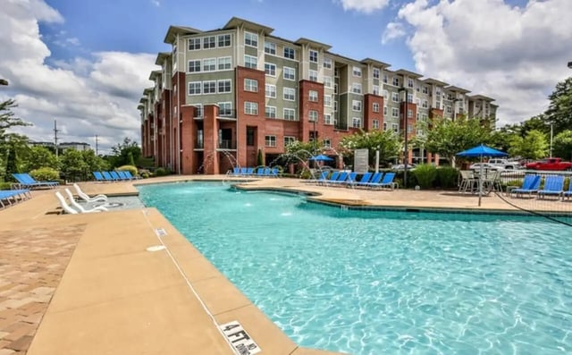 Apartment building with pool and lounge chairs exterior at The Flats At Carrs Hill in Athens Student Accommodation