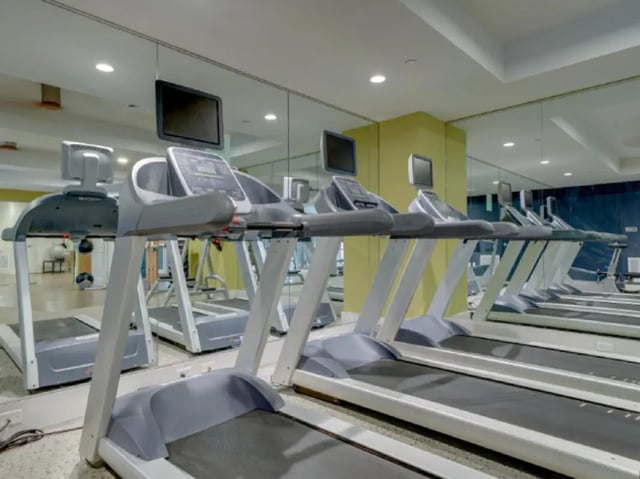 Row of treadmills with screens gym area at College and Crown Apartments in New Haven Student Accommodation