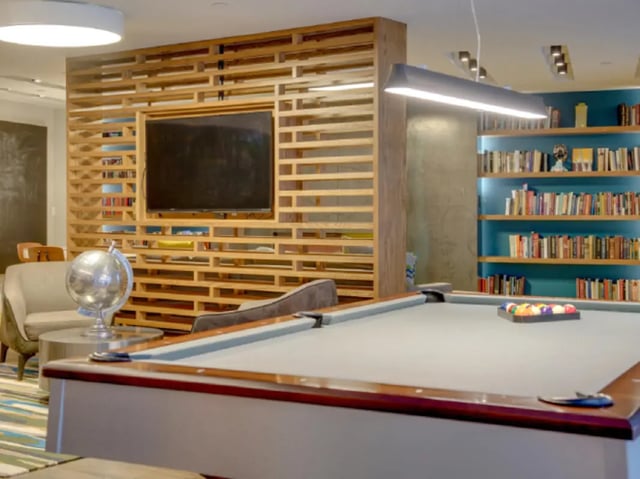 Pool table globe TV bookshelf seating lounge area at College and Crown Apartments in New Haven Student Accommodation