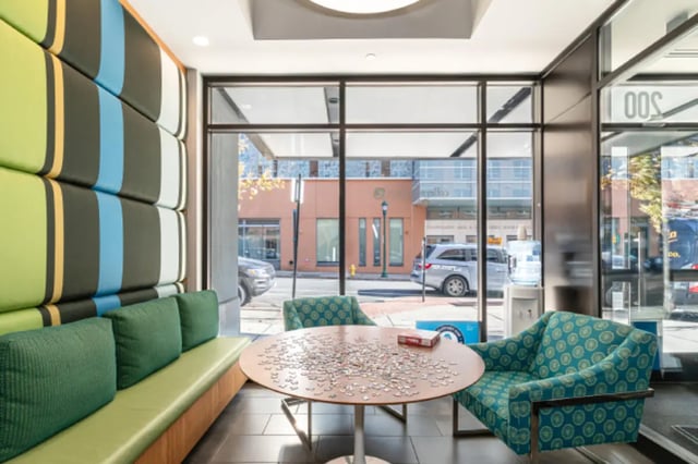 Colorful wall paneling puzzle table chairs living room at College and Crown Apartments in New Haven Student Accommodation