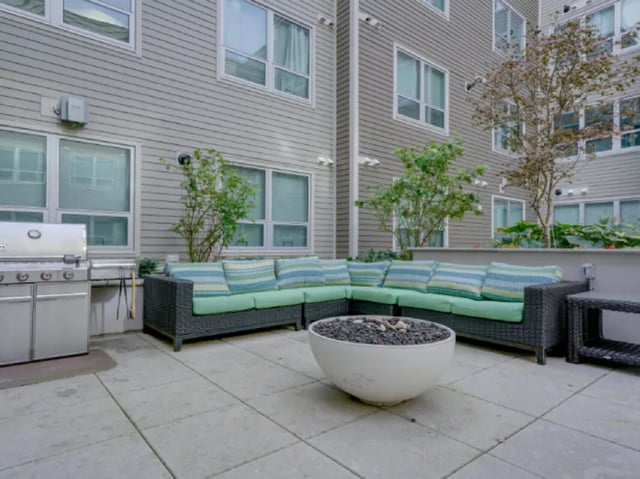 Grill sectional sofa fire pit patio area at College and Crown Apartments in New Haven Student Accommodation