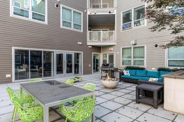 Outdoor patio with table chairs grill firepit seating area exterior at College and Crown Apartments in New Haven Student Accommodation