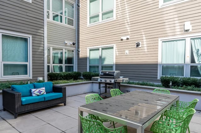 Sofa grill table green chairs outdoor living space at College and Crown Apartments in New Haven Student Accommodation