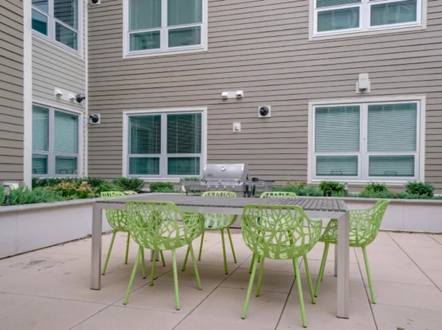 Table with lime green chairs grill exterior at College and Crown Apartments in New Haven Student Accommodation