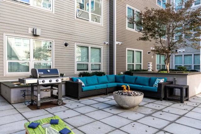 Grill couch fire pit cornhole game exterior at College and Crown Apartments in New Haven Student Accommodation