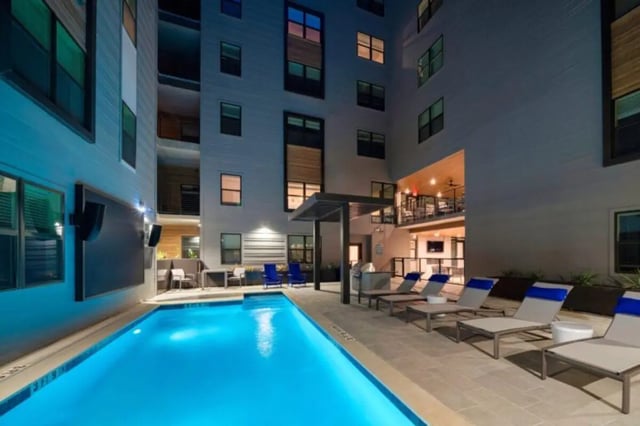 Pool lounge chairs and grill outdoor common area at Noble 2500 in Austin Student Accommodation