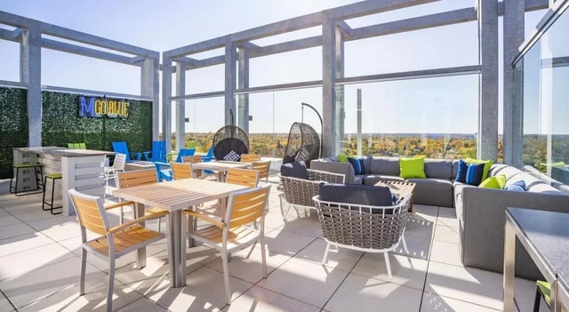 Seating tables bar stools swinging chairs sofas patio area at Sterling Arbor Blu in Ann Arbor Student Accommodation