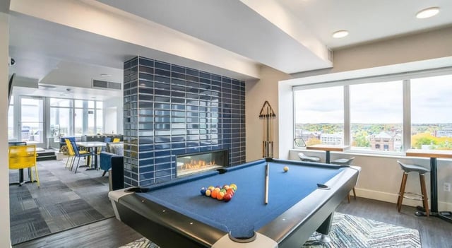 Pool table fireplace tables chairs living room at Sterling Arbor Blu in Ann Arbor Student Accommodation