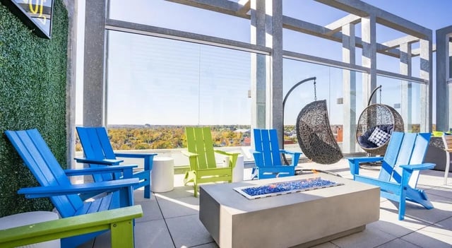 Colorful Adirondack chairs hanging chairs fire pit patio at Sterling Arbor Blu in Ann Arbor Student Accommodation