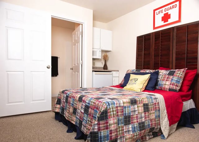 Bed with colorful quilt and pillows bedroom at Campus Communities - College Town Apartments in Big Rapids Student Accommodation