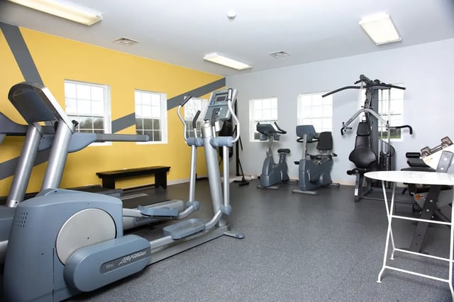Elliptical treadmills exercise bikes gym equipment fitness area at Campus Communities - College Town Apartments in Big Rapids Student Accommodation