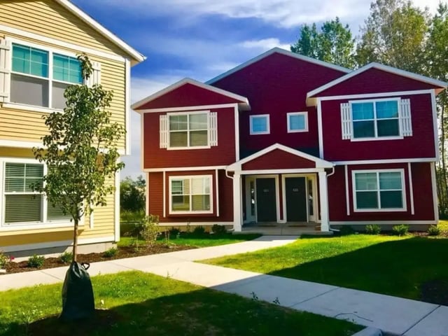 Red and yellow duplexes with white trim exterior at Campus Communities - College Town Apartments in Big Rapids Student Accommodation