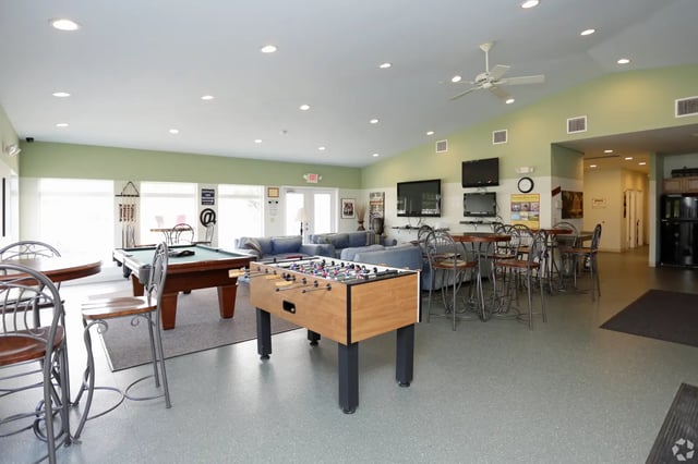 Pool table foosball table sofas seating living room at Campus Communities - College Town Apartments in Big Rapids Student Accommodation