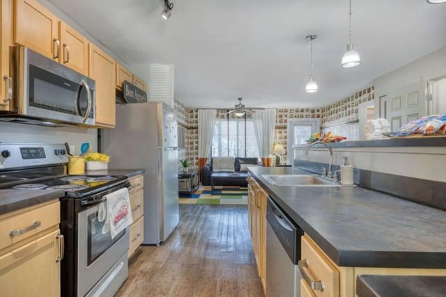 Kitchen with stainless appliances and living room view at The Thompson in San Marcos Student Accommodation