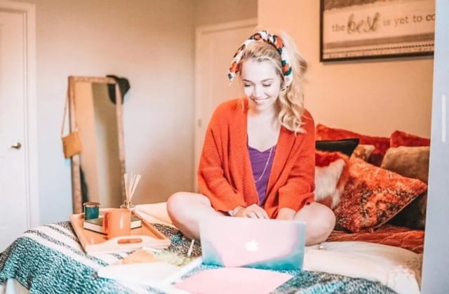 Woman with laptop on bed study area at The Thompson in San Marcos Student Accommodation