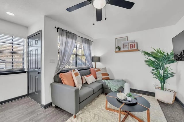 Gray sectional couch with pillows rug living room at The Timbers in San Marcos Student Accommodation