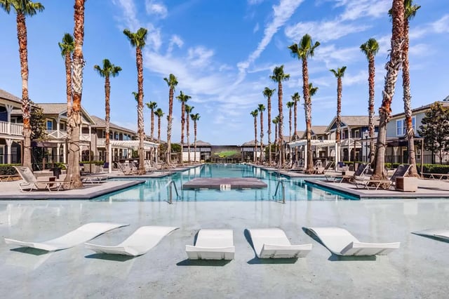 Poolside lounge chairs and resort complex exterior at Arlington Cottages and Townhomes in Baton Rouge Student Accommodation