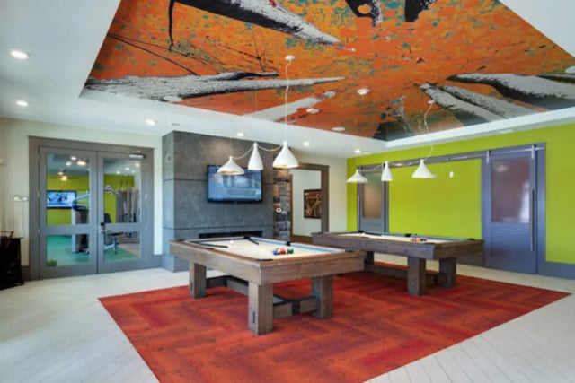 Pool tables under abstract ceiling art playing area at Brexx at Blacksburg in Blacksburg Student Accommodation