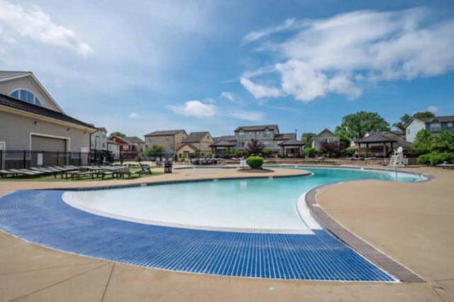 Curved pool with lounge chairs and buildings exterior at Brexx at Louisville in Louisville Student Accommodation