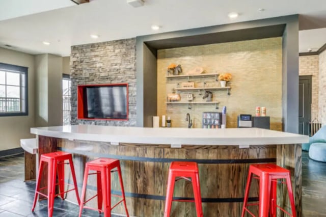 Bar with red stools and shelves Image Type Living Room at Brexx at Louisville in Louisville Student Accommodation