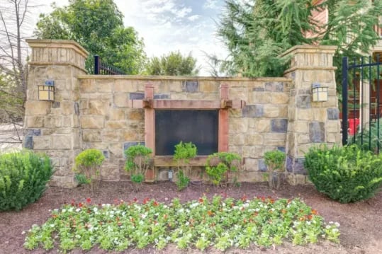 Stone wall with signage and garden exterior at Brexx at Louisville in Louisville Student Accommodation