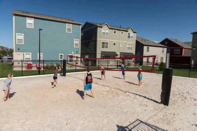 People playing volleyball in a sandy court exterior at Brexx at Louisville in Louisville Student Accommodation