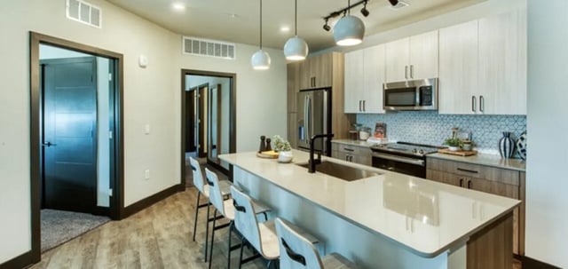 Island bar with pendant lights and kitchen appliances kitchen at Canvas in Tempe Student Accommodation