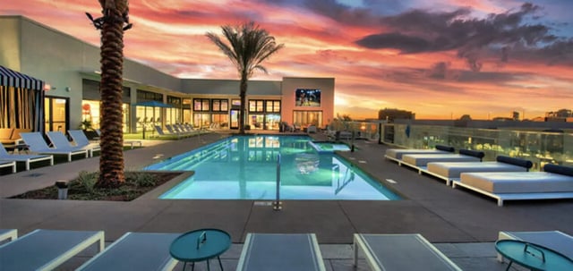 Pool lounge chairs and palm trees exterior at Canvas in Tempe Student Accommodation