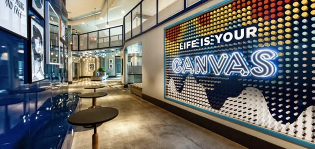 Modern communal area with seating and artwork hallway at Canvas in Tempe Student Accommodation