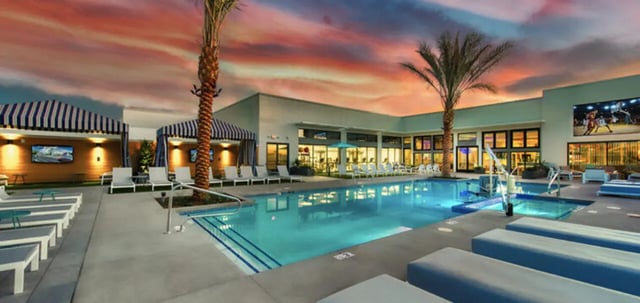 Pool lounge chairs palm trees large screen exterior at Canvas in Tempe Student Accommodation