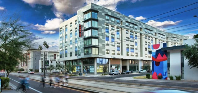 Modern apartment building with streetcars and people exterior at Canvas in Tempe Student Accommodation