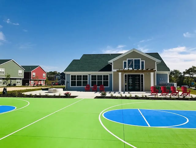 Colorful basketball court next to apartment buildings exterior at Campus Creek Cottages in Big Rapids Student Accommodation
