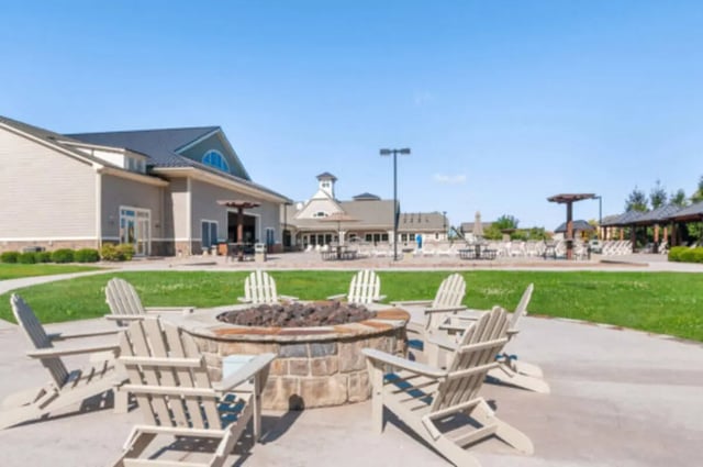 Adirondack chairs around stone fire pit exterior at Brexx at State College in State College Student Accommodation