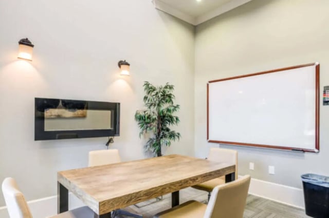 Table chairs whiteboard plant and television meeting room at Brexx at State College in State College Student Accommodation