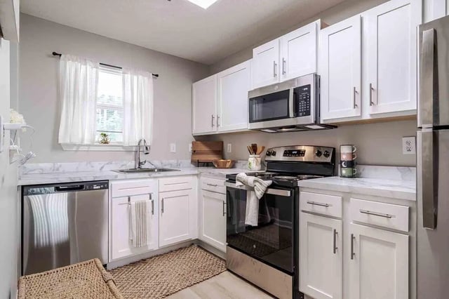 White cabinets sink dishwasher microwave oven kitchen at The Townhomes At River Club in Athens Student Accommodation