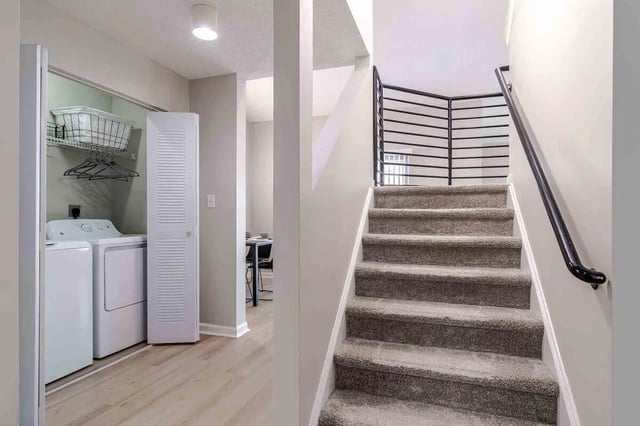 Washer dryer closet and carpeted stairs interior. at The Townhomes At River Club in Athens Student Accommodation