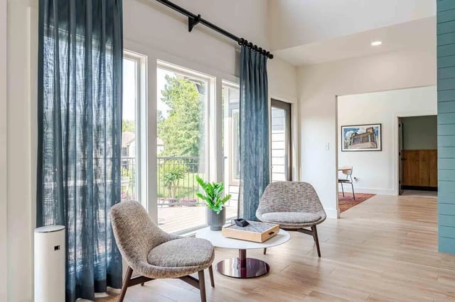 Two chairs plant on table large window living room at The Townhomes At River Club in Athens Student Accommodation