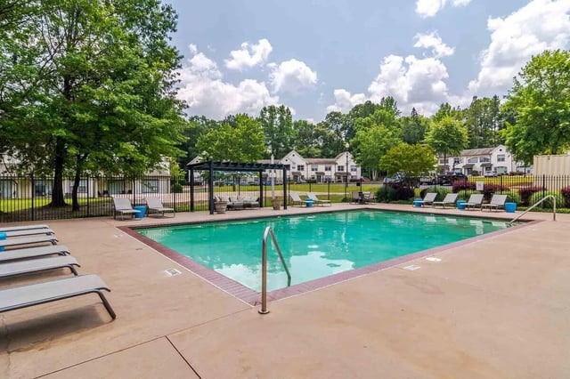 Pool with lounge chairs and buildings exterior at The Townhomes At River Club in Athens Student Accommodation