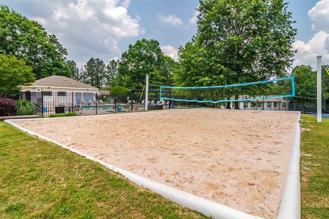 Volleyball court with net and sandy surface playing area at The Townhomes At River Club in Athens Student Accommodation
