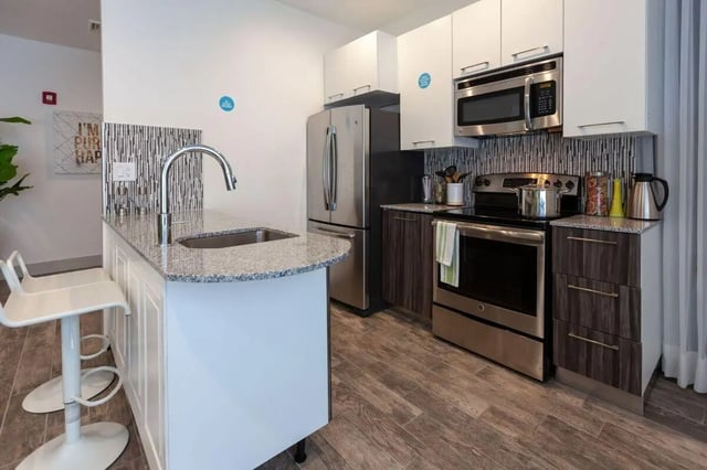 Kitchen island sink oven refrigerator and cabinets kitchen at The Printing House in Binghamton Student Accommodation